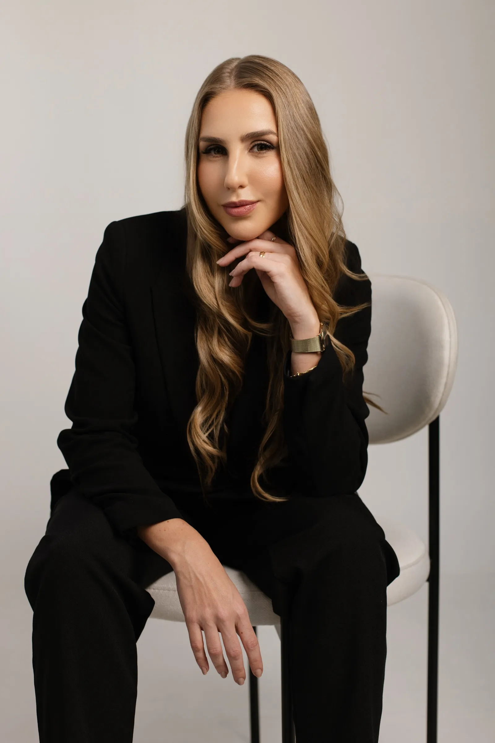 Dra. Rayana Deschamps de terno preto, sentada